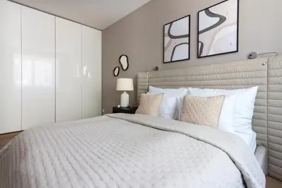 a white bedroom with a large bed with white pillows at Modern apartment near Old Town in Prague