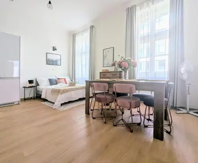 a living room with a table and chairs and a bed at New Town 2 BDR, free coffee in Prague