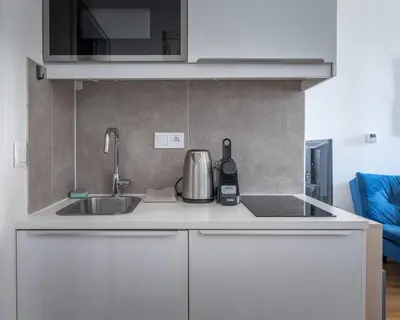 a kitchen with white cabinets and a sink at Central Studio by Museum and Old Town in Prague