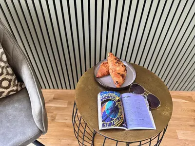 a table with a plate of pizza and a book at No2 Style & Design XXL City Centre Apartment in Prague