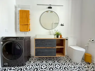 a bathroom with a washing machine and a mirror at No2 Style & Design XXL City Centre Apartment in Prague