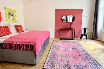 a bedroom with a bed and a rug and a mirror at No2 Style & Design XXL City Centre Apartment in Prague