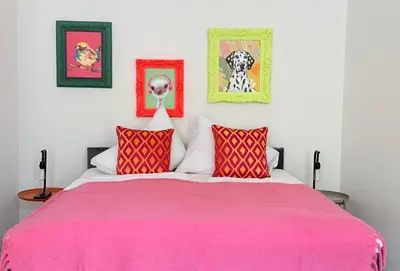 a bedroom with a pink bed with two red pillows at No2 Style & Design XXL City Centre Apartment in Prague