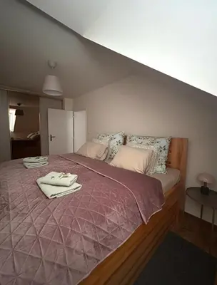 a bedroom with a large bed with a purple blanket at Apartment Drahuska in Prague