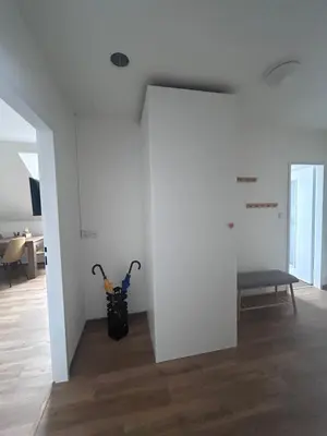 a white room with a bench and two vacuum cleaners at Apartment Drahuska in Prague