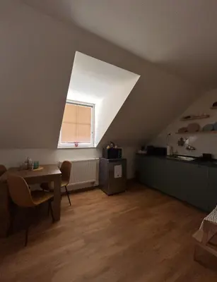 an attic room with a table and a window at Apartment Drahuska in Prague
