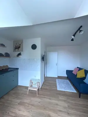 a living room with a blue couch and a chair at Apartment Drahuska in Prague