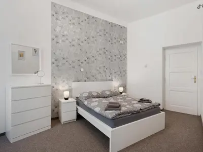 a white bedroom with a bed and a wall at Apartment Old Town home-7 by Interhome in Prague