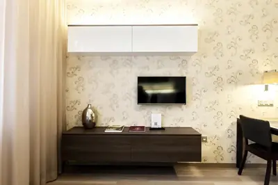 a dining room with a table and a tv on a wall at VINOHRADSKY DUM Residence in Prague