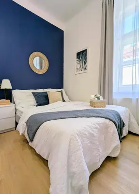 a bedroom with a large bed with a blue wall at New Town Studio, free coffee in Prague