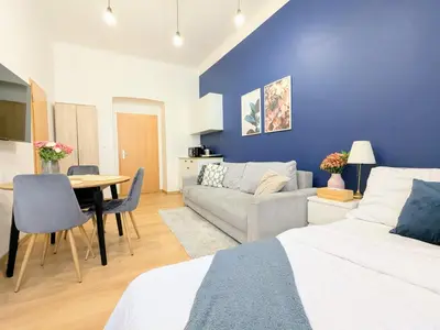 a living room with a bed and a couch and a table at New Town Studio, free coffee in Prague