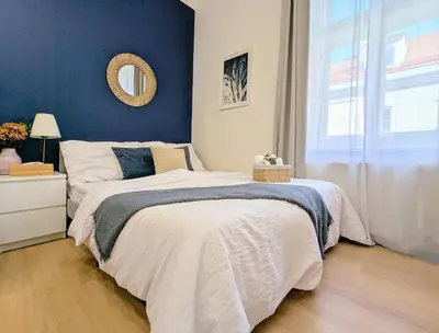 a bedroom with a large bed with a blue wall at New Town Studio, free coffee in Prague