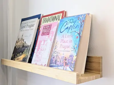 four books sitting on a book shelf at New Town Studio, free coffee in Prague