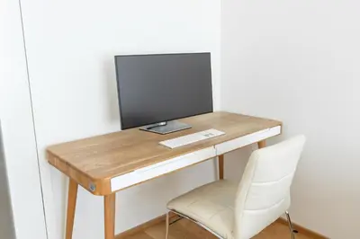 a desk with a computer on it with a chair at Contemporary apartment with garage parking in Prague