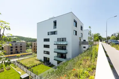 an external view of a white building with a garden at Contemporary apartment with garage parking in Prague