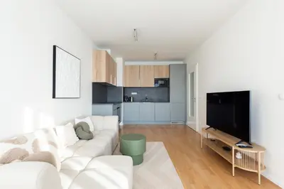 a living room with a white couch and a flat screen tv at Cool All-in Apartment Prague in Prague