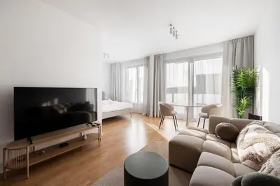 a living room with a couch and a flat screen tv at Cool All-in Apartment Prague in Prague