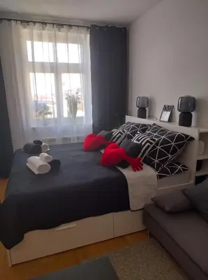 a bedroom with a large bed with red pillows at Комфортная, уютная,романтичная in Prague