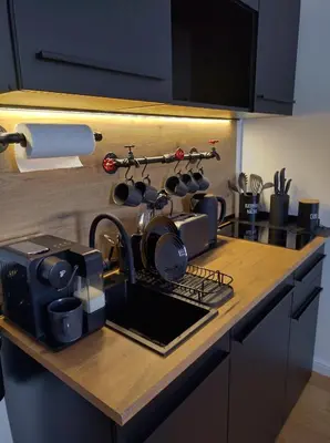 a kitchen counter with a sink with pots and pans at Комфортная, уютная,романтичная in Prague