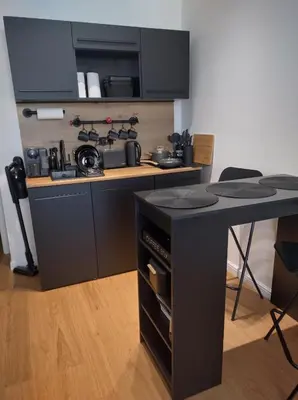 a kitchen with a black counter and a table at Комфортная, уютная,романтичная in Prague