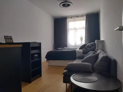 a living room with a couch and a bed at Комфортная, уютная,романтичная in Prague