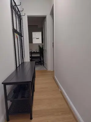 a hallway with a wooden floor and a black table at Комфортная, уютная,романтичная in Prague