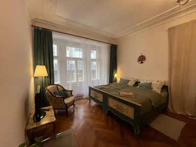 a bedroom with a bed and a chair and a window at Štepánská 3 in Prague