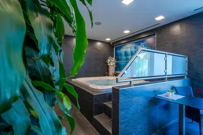 a bathroom with a tub and a large plant at Hotel u Ledu in Velké Popovice