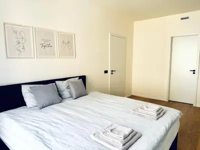 a bedroom with a white bed with towels on it at Lengo Apartment Smichov in Prague
