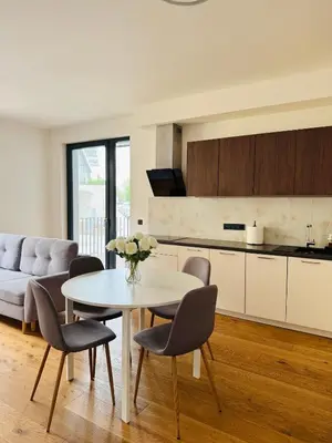 a kitchen and living room with a table and chairs at Lengo Apartment Smichov in Prague