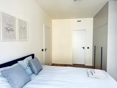 a bedroom with a large white bed with blue pillows at Lengo Apartment Smichov in Prague