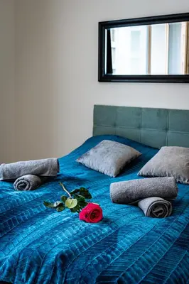 a blue bed with a rose on top of it at Elvis Deluxe Suite in Prague