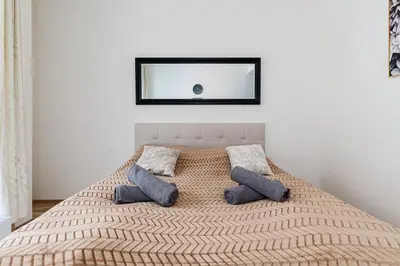 a bed with two pillows and a mirror on the wall at Elvis Deluxe Suite in Prague