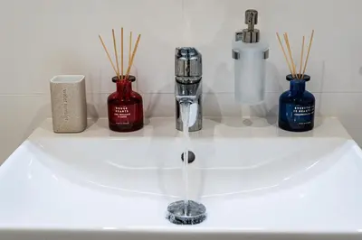 a bathroom sink with a faucet and three bottles at Elvis Deluxe Suite in Prague