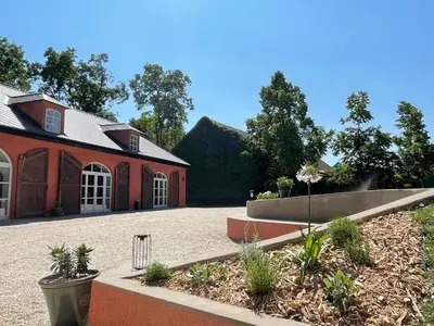 a large red building with a courtyard in front of it at Zámecká Stodola - Červený Hrádek u Sedlčan in Sedlčany