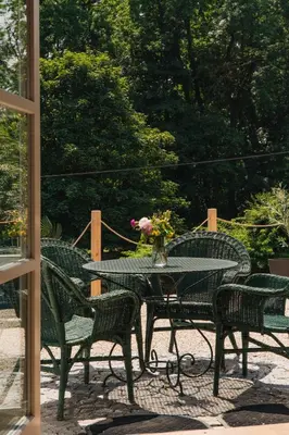 a table and chairs with a vase of flowers on it at Zámecká Stodola - Červený Hrádek u Sedlčan in Sedlčany