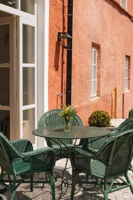 a patio table with chairs and a vase of flowers at Zámecká Stodola - Červený Hrádek u Sedlčan in Sedlčany