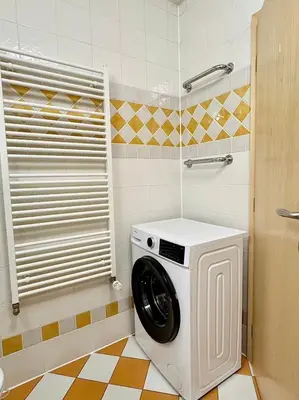 a washing machine in the corner of a bathroom at Lumi Retreat Prague in Prague