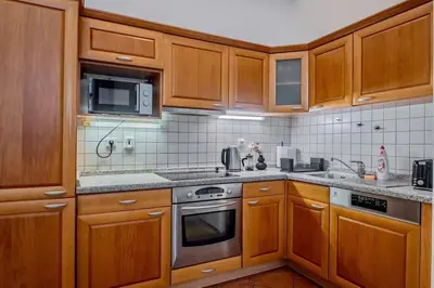 a kitchen with wooden cabinets and stainless steel appliances at Lumi Retreat Prague in Prague