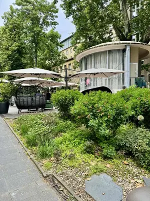 a table and chairs with umbrellas in front of a building at Lumi Retreat Prague in Prague