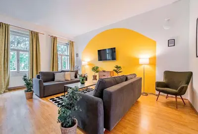 a living room with a couch and chairs and a tv at Lumi Retreat Prague in Prague