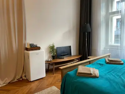 a room with a bed and a desk with a television at Štěpánská in Prague