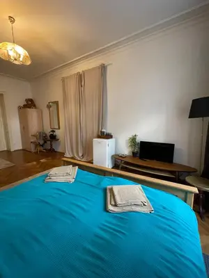 a large blue bed in a room with a table at Štěpánská in Prague