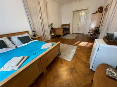 a bedroom with a large bed with blue sheets at Štěpánská in Prague