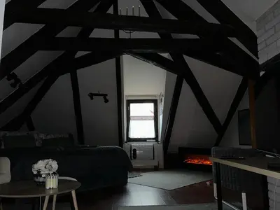 an attic room with a bed and a fireplace at Apartmány na náměstí - Kounice in Kounice