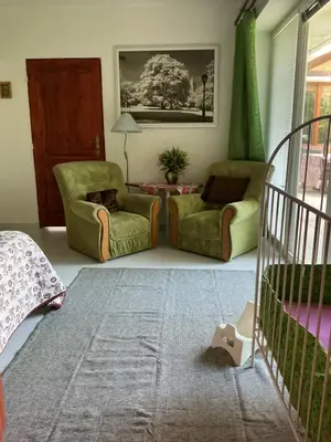 a living room with two chairs and a crib at Apartmány na náměstí - Kounice in Kounice