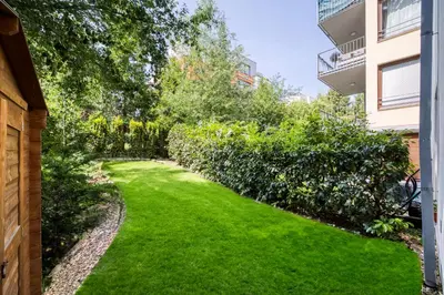 a garden with green grass in a building at Apartment with garden in Prague 6 in Prague