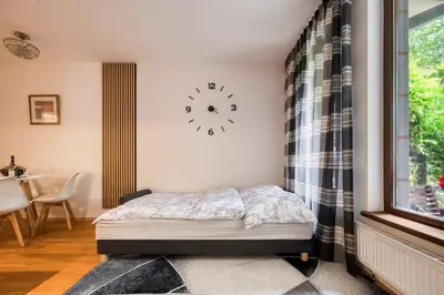 a bedroom with a bed and a clock on the wall at Apartment with garden in Prague 6 in Prague