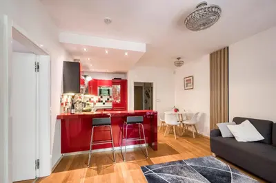 a red kitchen with a red counter in a living room at Apartment with garden in Prague 6 in Prague
