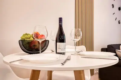 a white table with a bottle of wine and glasses at Apartment with garden in Prague 6 in Prague